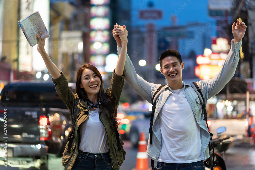 亚洲夫妇夜晚在城市度蜜月旅行的肖像。