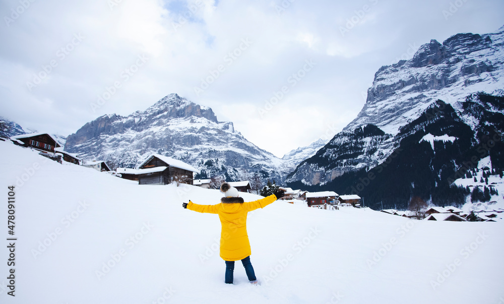 Grindelwald瑞士欧洲之巅，身穿黄色外套的亚洲女性。她在真空吸尘器上感到很开心