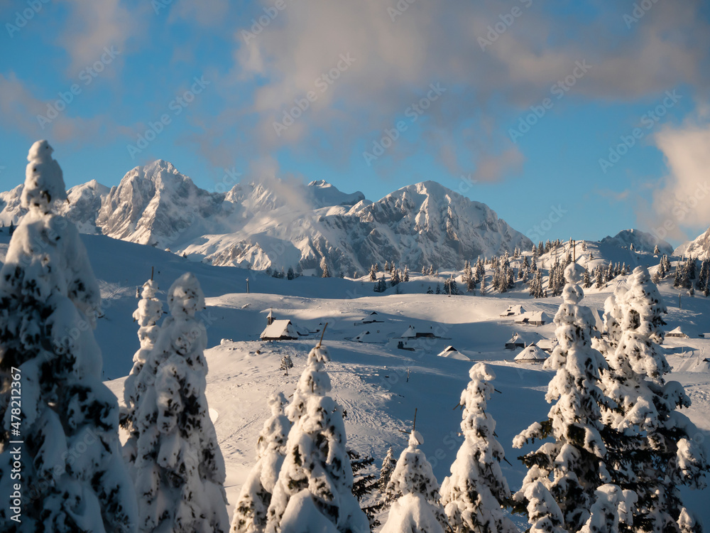 AERIAL：飞过雪中的云杉，露出日出时美丽的Velika Planina