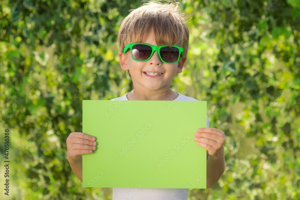 Happy child showing recycle sign outdoor in spring park