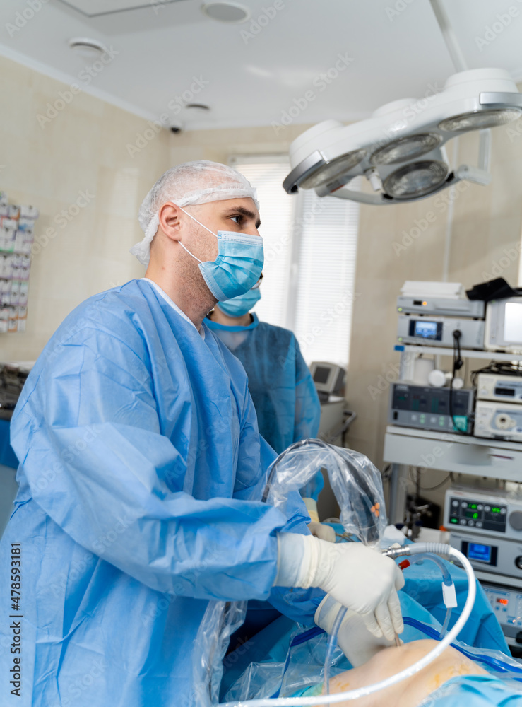 Waist up portrait of the young male caucasian assistant or intern wearing medical face mask standing