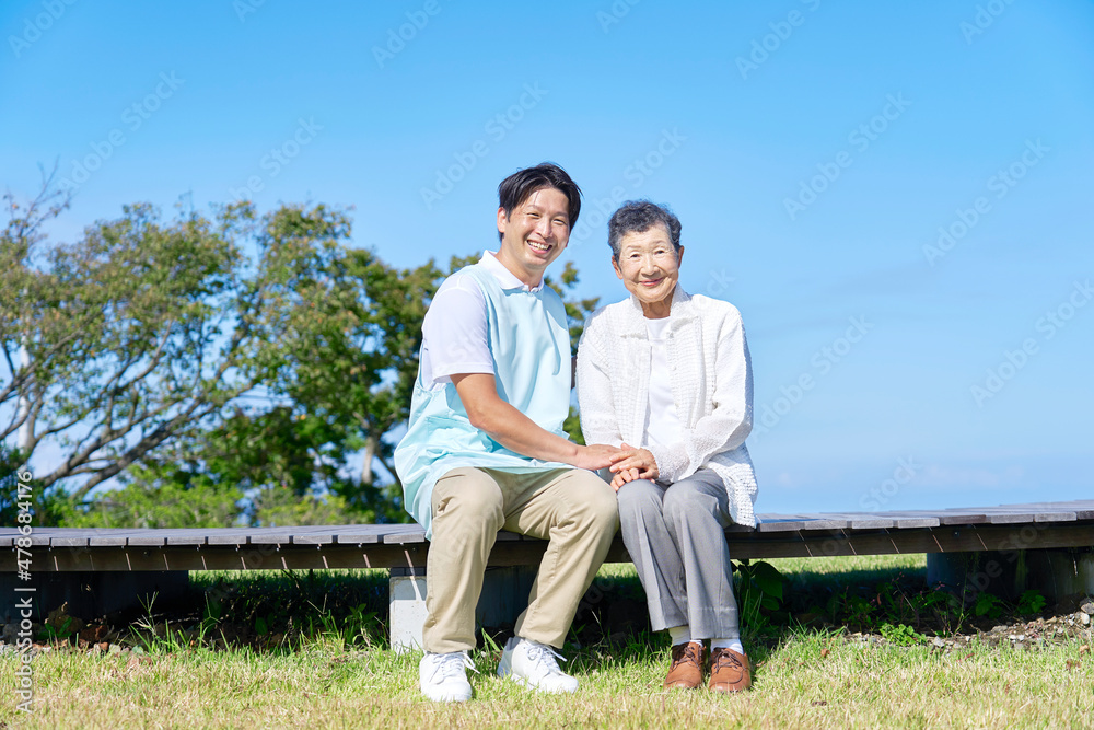 介護士と高齢者　屋外