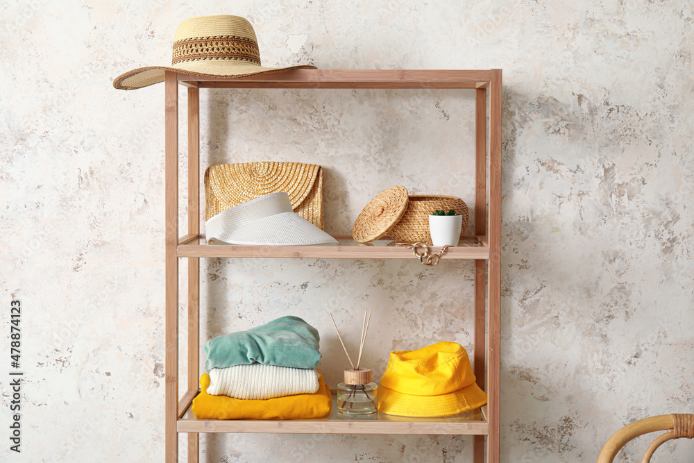 Shelving unit with accessories and reed diffuser near light wall