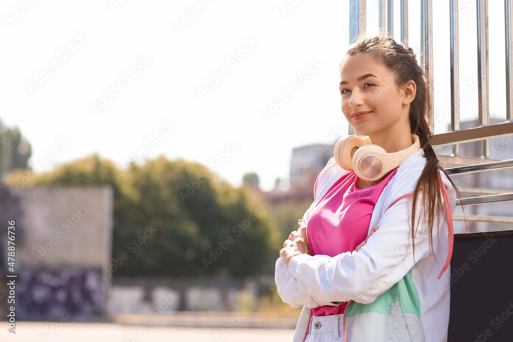 漂亮的年轻女人在户外听音乐