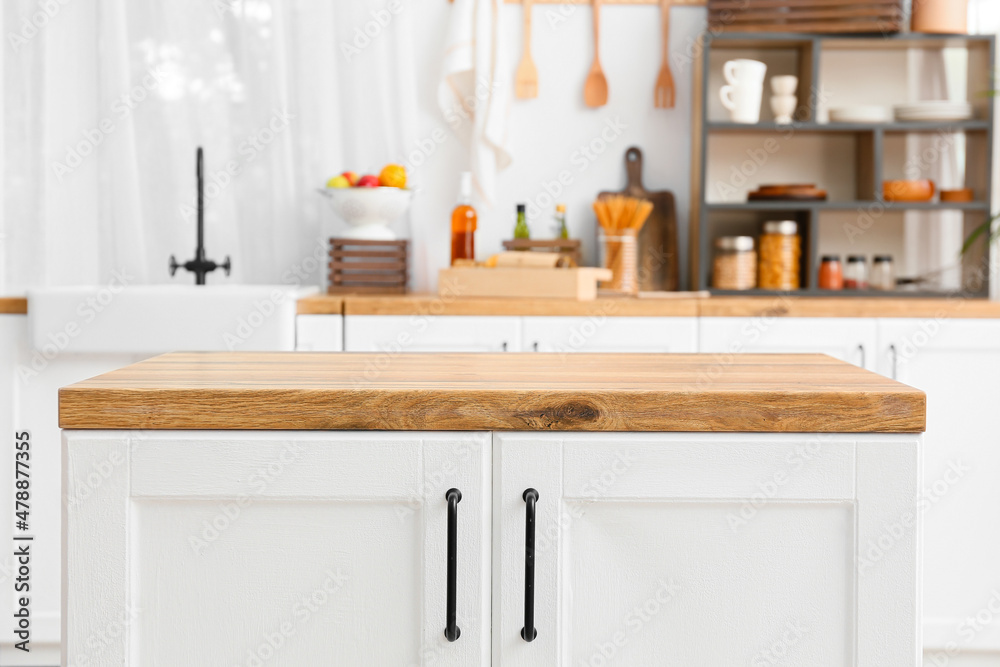 White counter with wooden table top in light kitchen