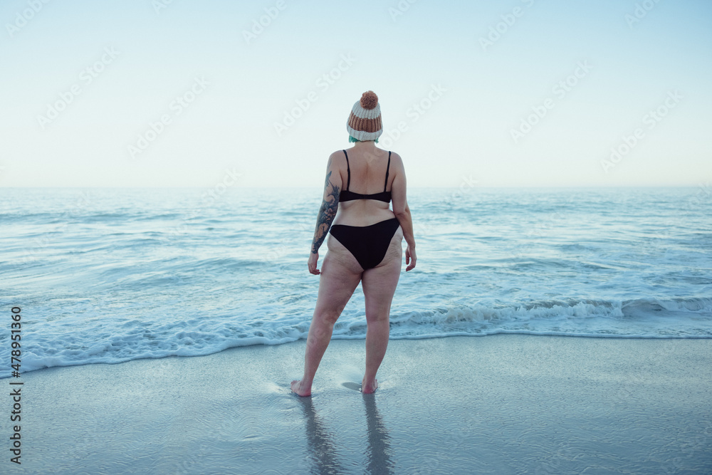 中年妇女在海滩上看海浪