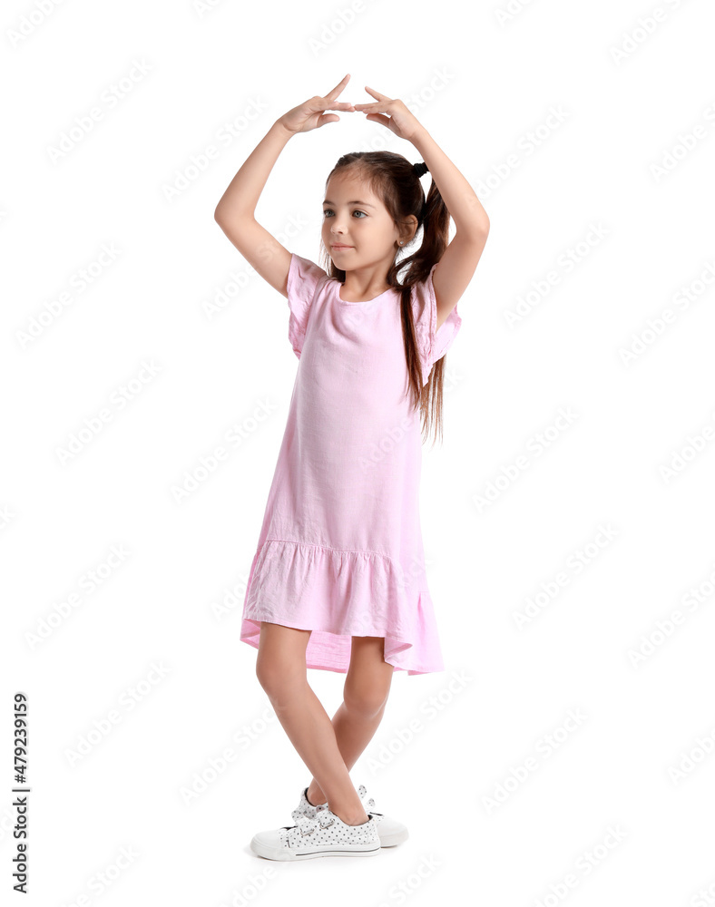 Adorable little girl in pink dress dancing on white background