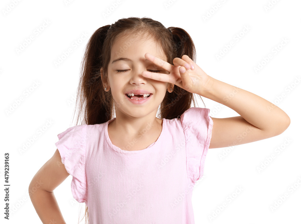 Adorable little girl in pink dress showing victory gesture on white background