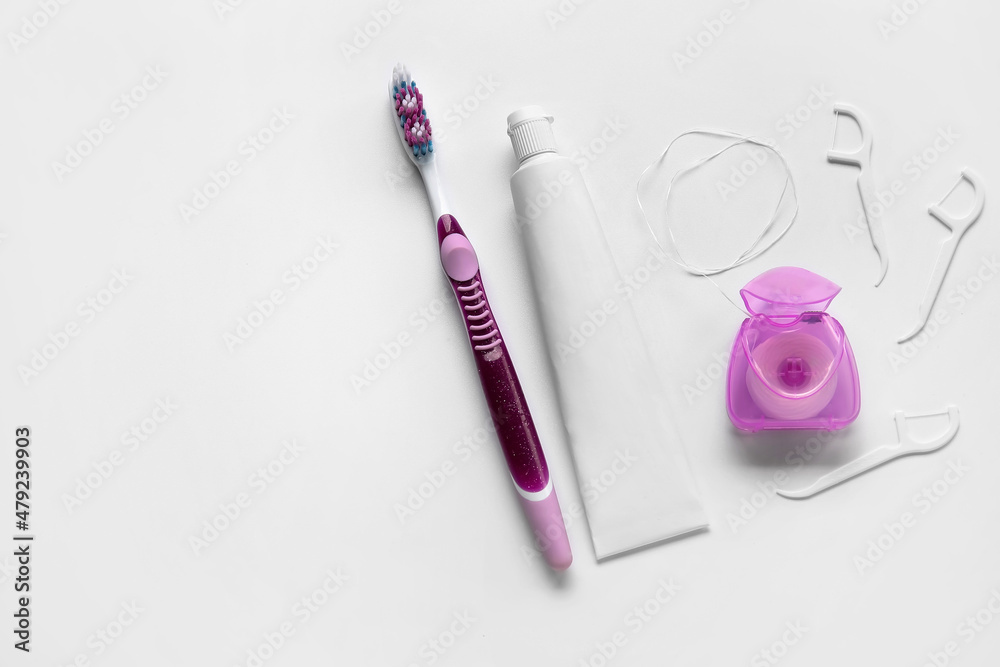 Dental floss, toothpicks, paste and brush on white background