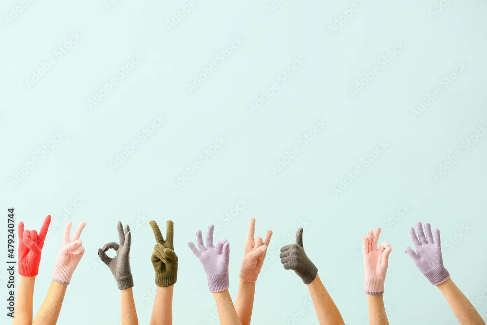 Women in warm gloves showing different gestures on blue background