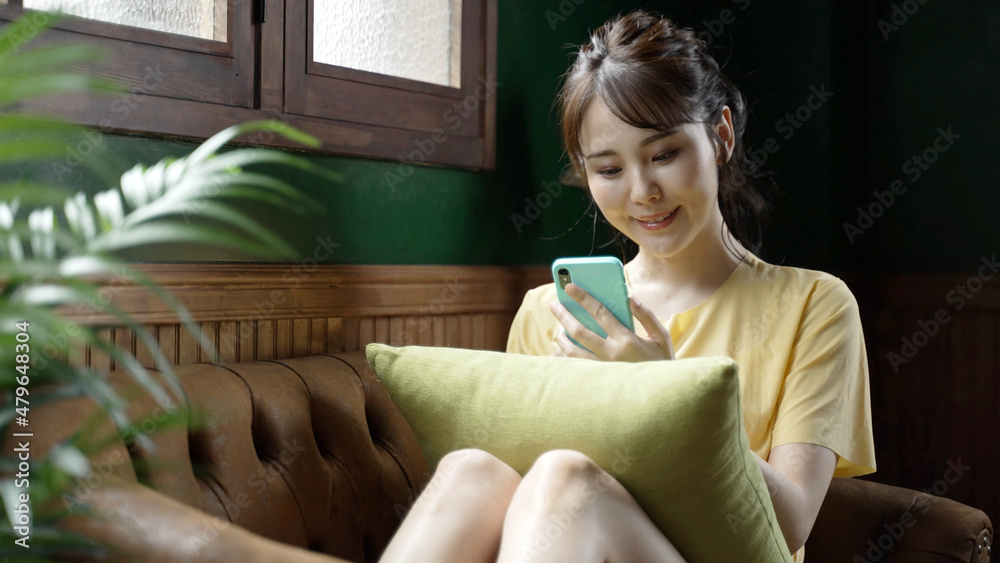 アンティークな部屋でスマートフォンを使う女性