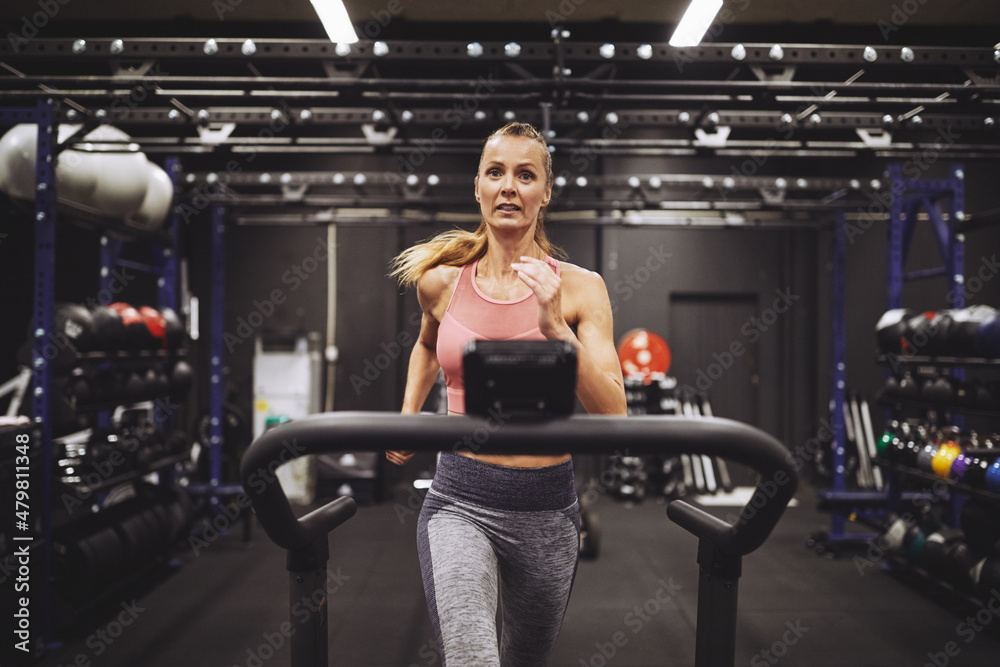 Mature woman working out on a treadmill at the gym