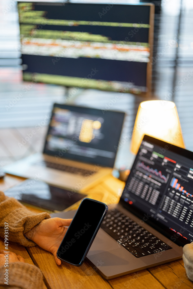 Cozy workplace with laptop and desktop computers with programming code on the screens. Programmer wo