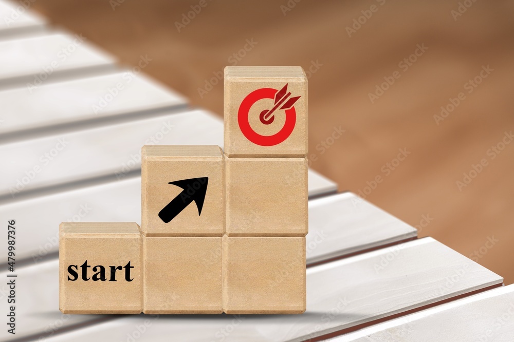 Starting point and a wooden cube with an arrow pointing to the target icon. Business success concept