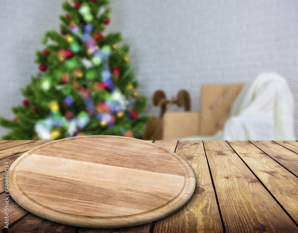 Wooden tabletop with a blurred kitchen with Christmas tree. Background for display or montage your p