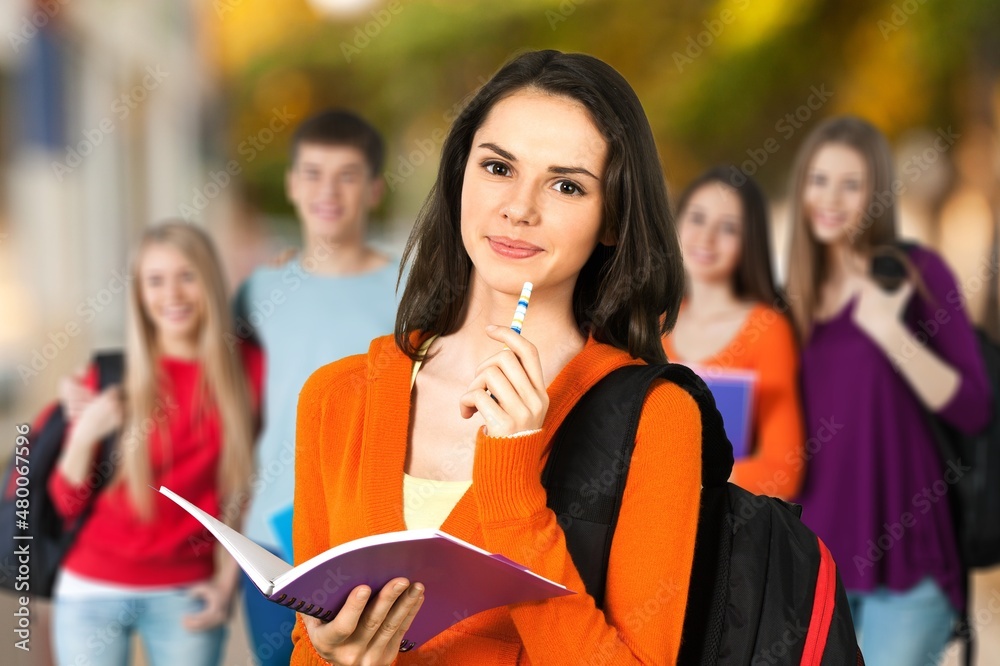 Laughing female student with group of multi ethnic young adults outdoor in city