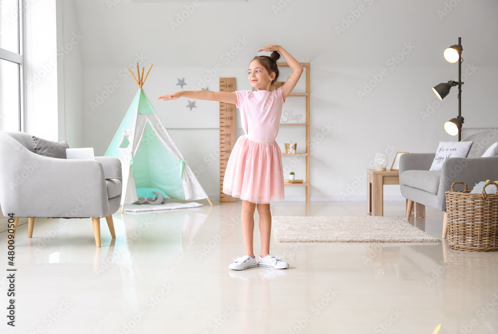 Adorable little ballerina dancing at home