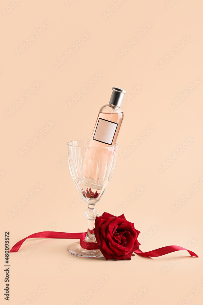 Perfume, glass and rose for Valentines day on beige background