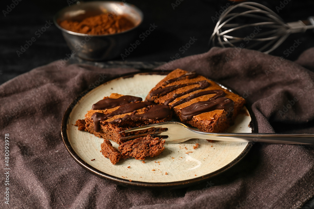 Plate with pieces of tasty chocolate brownie on table