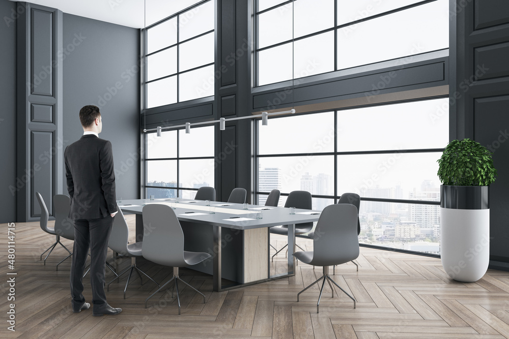 Businessman standing in modern wooden and concrete meeting room interior with panoramic city view, f