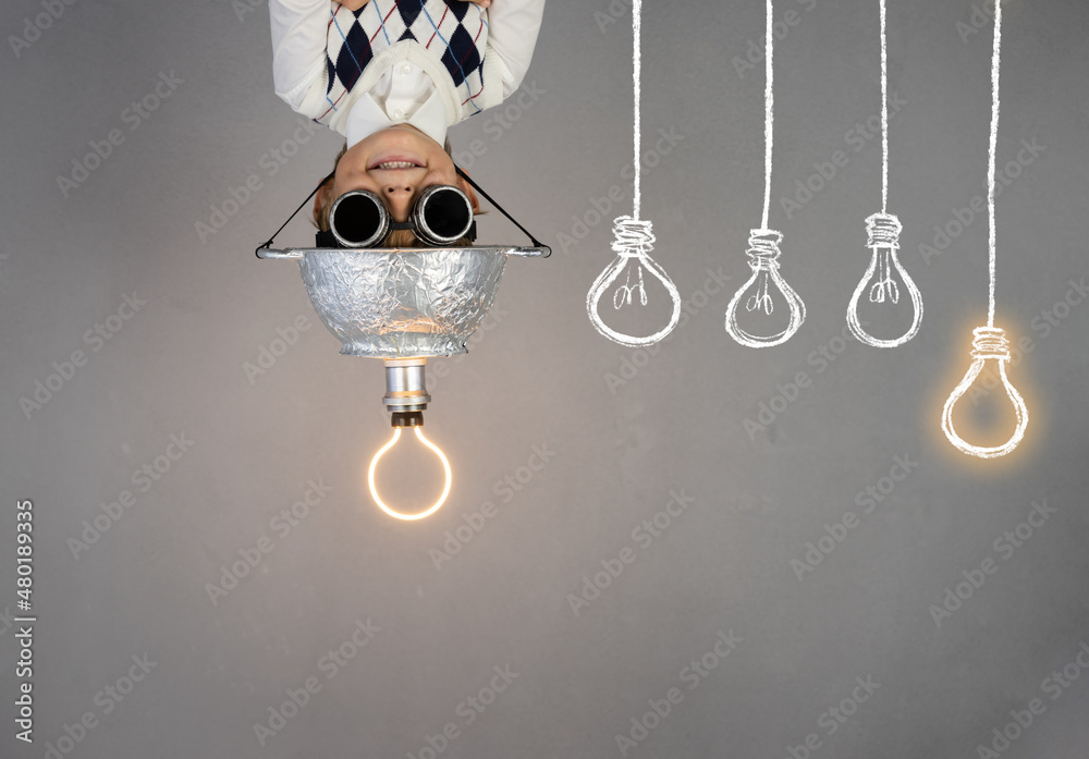 Smart child wearing funny helmet with illuminated lightbulb