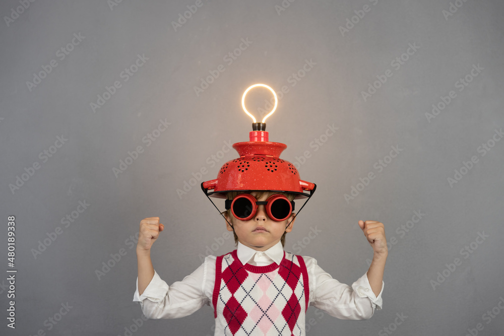 Smart child wearing funny helmet with illuminated lightbulb