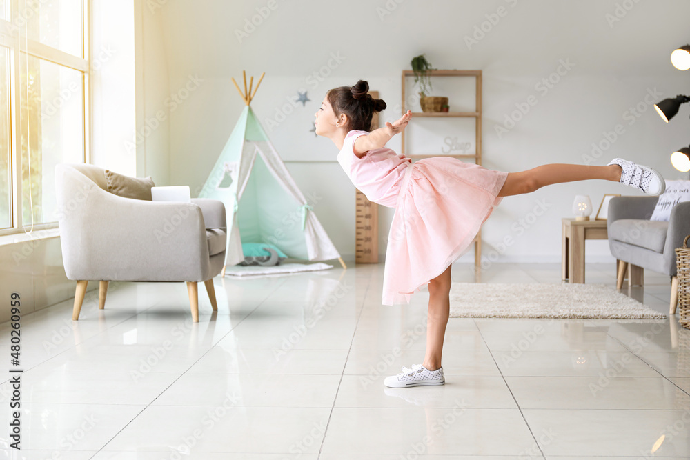 Adorable little ballerina dancing at home