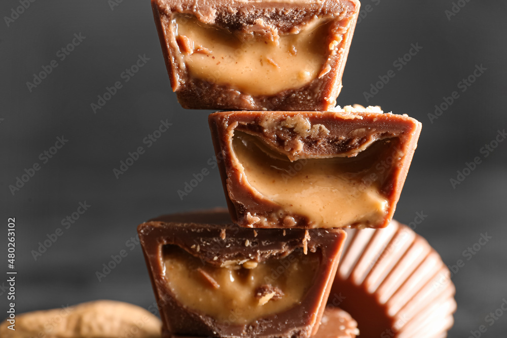 Tasty chocolate candies with peanut butter on dark background, closeup