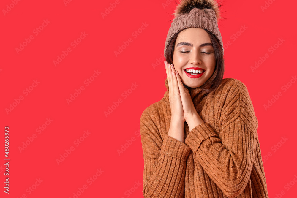 Pretty young woman in warm sweater on color background