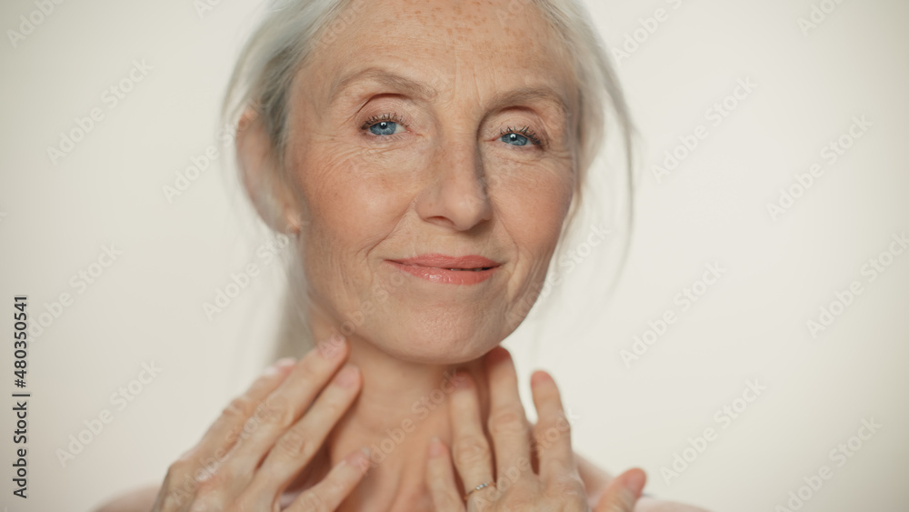 Portrait of Senior Woman Looking at Camera, Touching Hair, Beautiful Face, Smiling. Elderly Female w