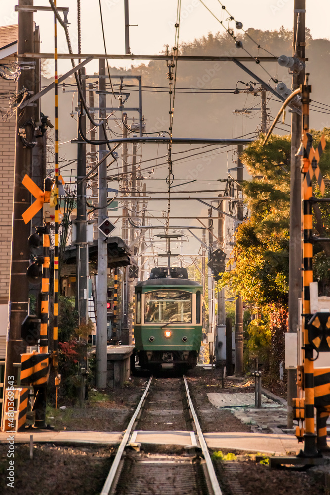 住宅の裏の狭い隙間を走るローカル線