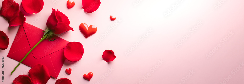 Red rose petals and invitation