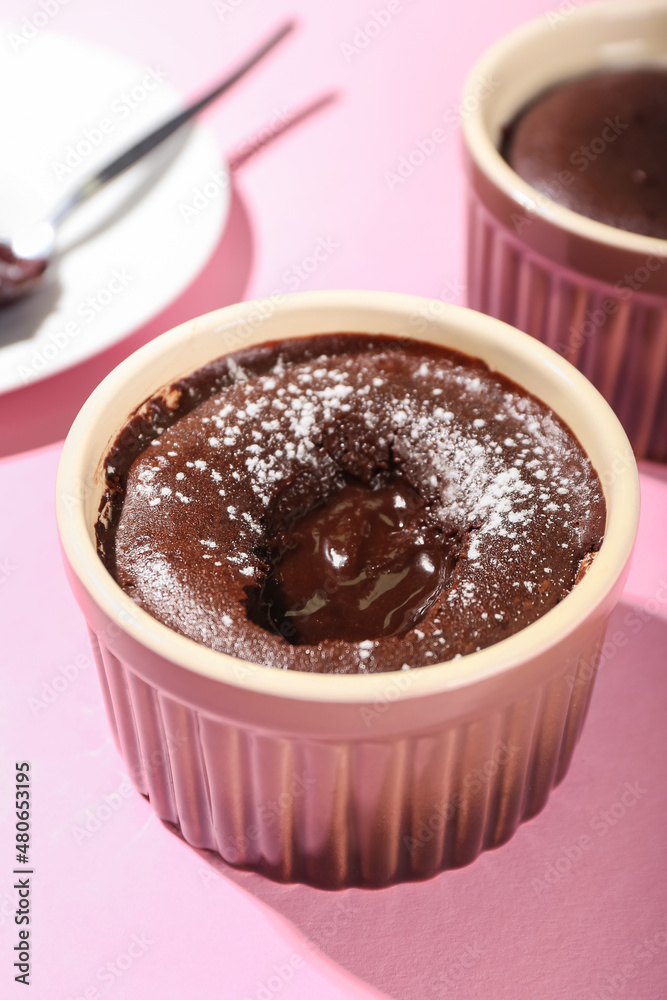 Ramekin with tasty lava cake fondant on pink background, closeup