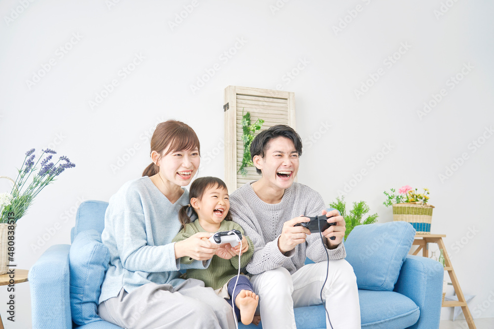 テレビゲームで遊ぶ家族