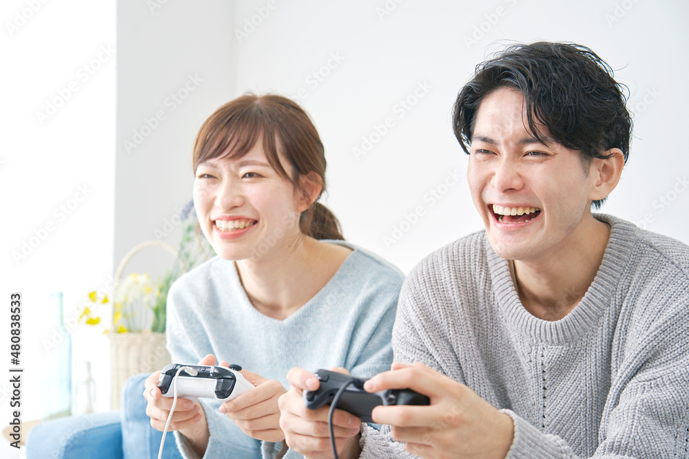 テレビゲームで遊ぶカップル