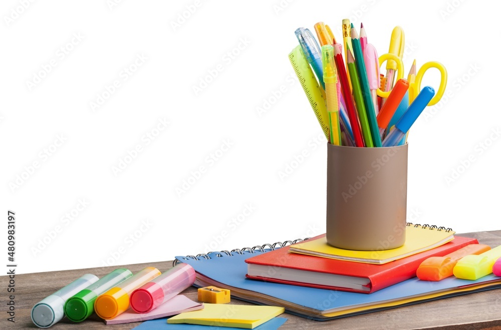 Colored school supplies on wooden table