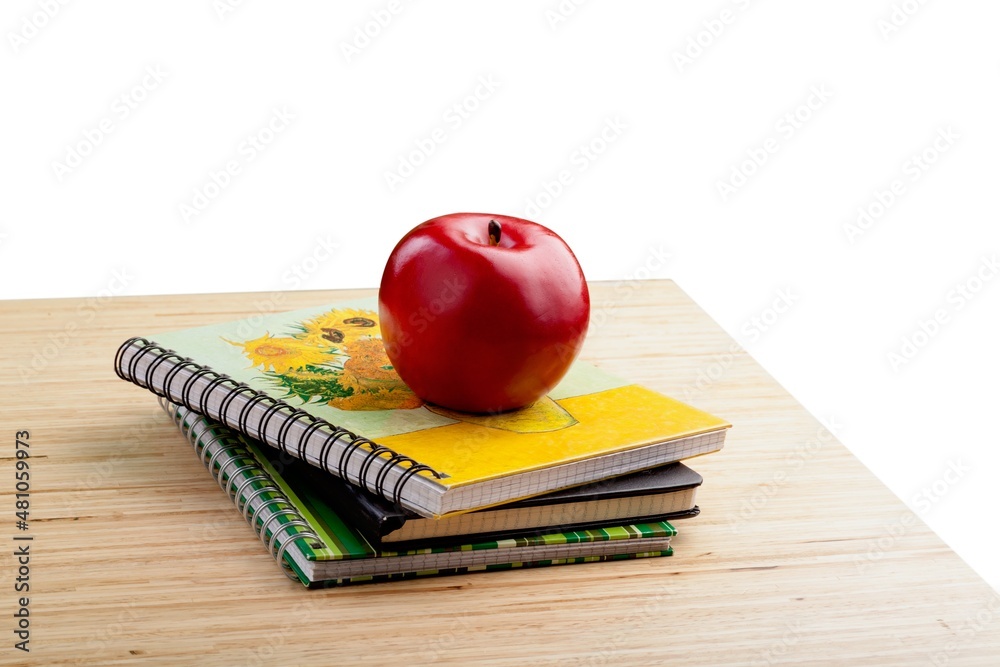 School teachers desk with stack of books and apple