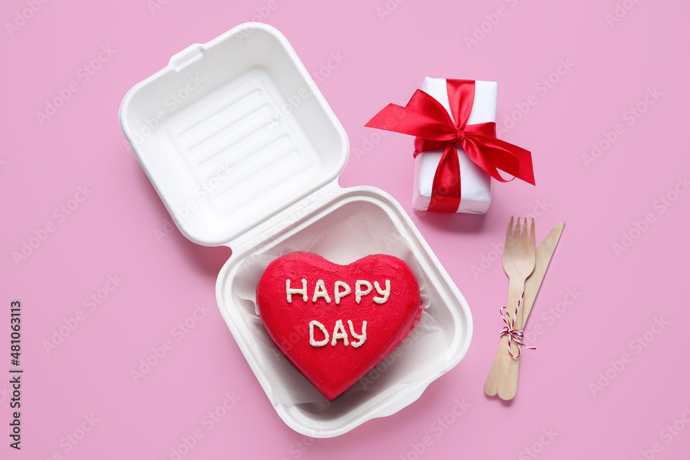 Plastic lunch box with tasty bento cake and gift for Valentines Day on pink background