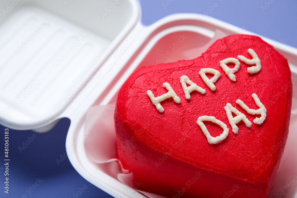 Plastic lunch box with tasty bento cake for Valentines Day on purple background, closeup