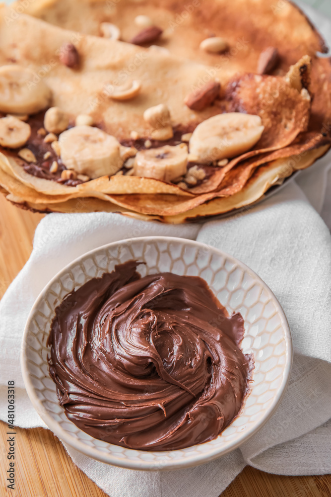 Bowl of tasty chocolate paste on table