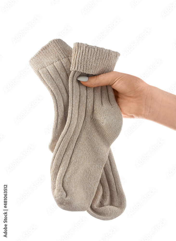 Woman holding pair of socks on white background