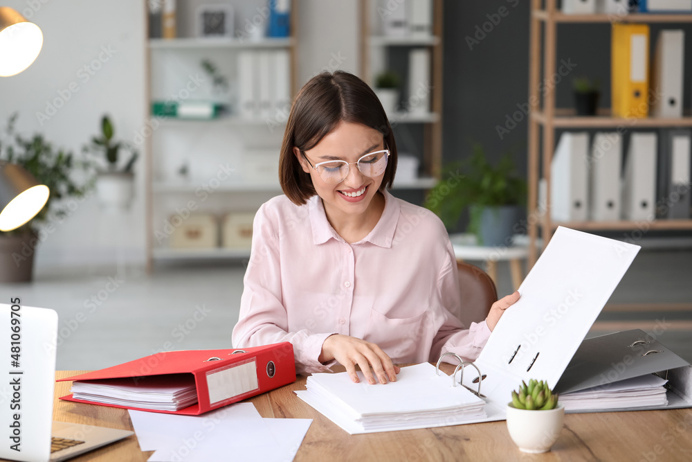 Young woman working with documents in office