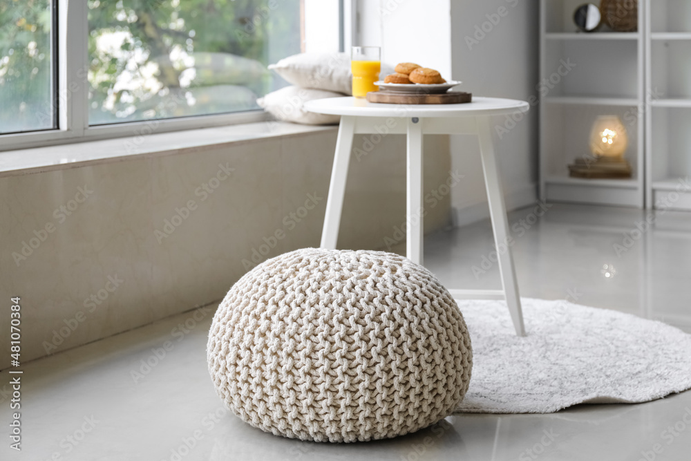 Knitted pouf in interior of living room