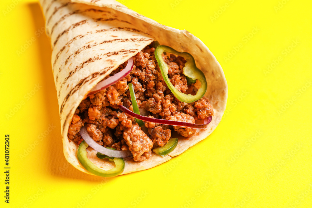 Tasty burrito on yellow background, closeup