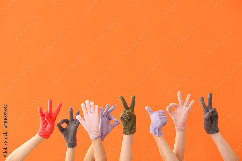 Women in warm gloves showing different gestures on orange background