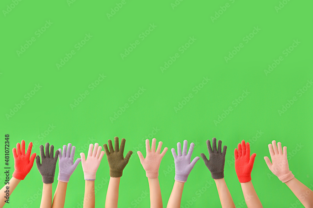 Women in warm gloves on green background