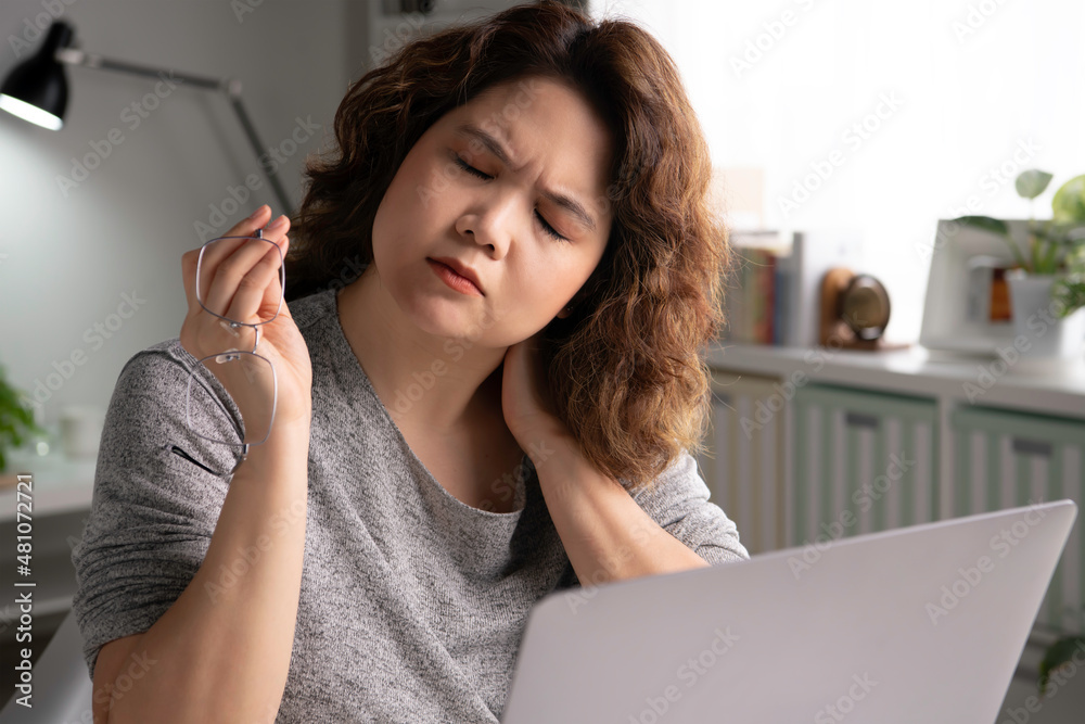 Feeling tired and stressed. Young Asian businesswoman sitting looking exhausted and tired during wor