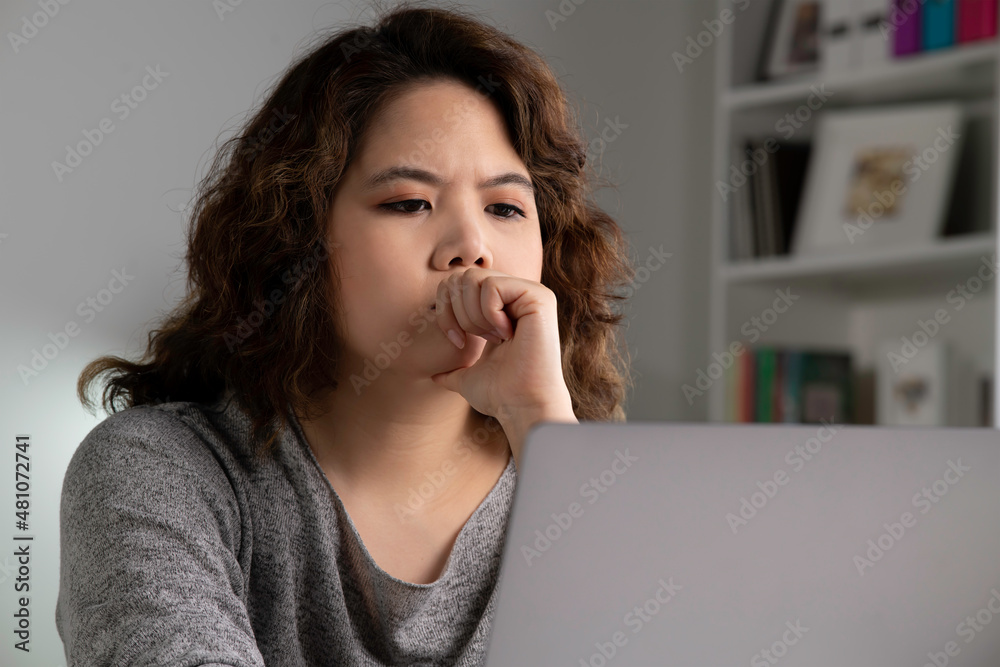 感到疲惫和压力。年轻的亚洲女性坐在那里沉思，疲惫不堪