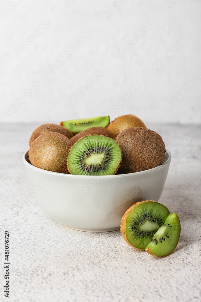 Bowl with fresh ripe kiwi on light background