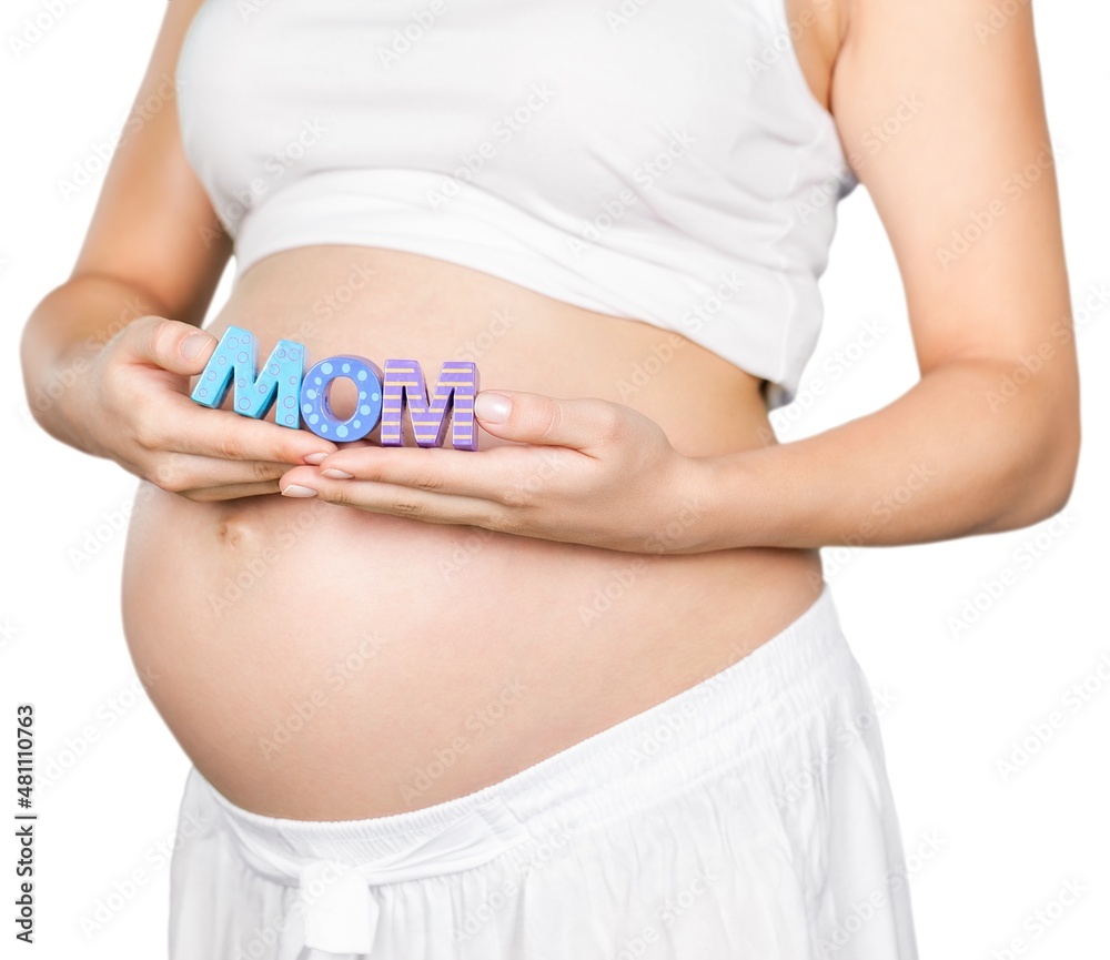 Pregnant woman holding a letter mom in hands